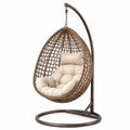 Poltrona sospesa a uovo 110 × 110 × 200 cm in rattan sintetico marrone con cuscini beige e supporto in acciaio